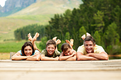 Buy stock photo Portrait, family and happy outdoor on pier for summer holiday, vacation and together in countryside. Mountains, love and smile of man, woman and children in nature to relax, bonding and connection