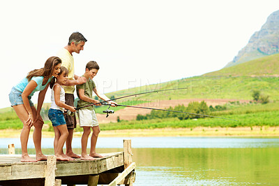 Buy stock photo Fishing, dock and parents with kids by lake for summer vacation, holiday and bonding together. Family, nature and pier with mom, dad and children for adventure, space and learning to catch fish