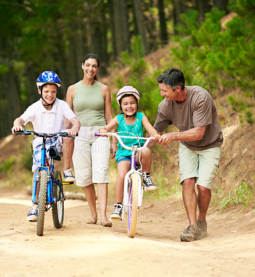 Buy stock photo Lesson, father or children in nature with bicycle, bonding together and support in summer hobby. Smile, cycling and family with help, teaching moment and parent connection for childhood development.