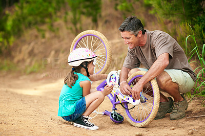 Buy stock photo Father, fixing and bicycle outdoor with child, safety check and repair chain for cycling. Smile, man and helping daughter in nature with bike, mechanical skills and maintenance inspection for bonding