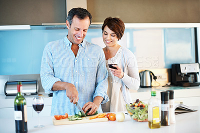 Buy stock photo Love, happy couple and cooking with red wine, slice vegetables and organic nutrition in home. Mature man, woman and meal prep with alcohol glass at kitchen, healthy cucumber and vegetarian diet