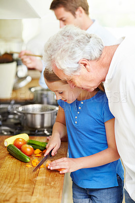 Buy stock photo Cooking, cutting and teaching with child and grandfather in kitchen for help, lunch and food. Love, vegetables and learning with old man and granddaughter in family home for wellness and support