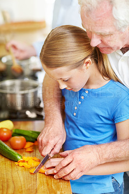 Buy stock photo Helping hand, chopping and child with grandpa for cooking, learning or practice with meal ingredients. Peppers, prepare food together and old man showing skills, teaching girl kid and bonding in home