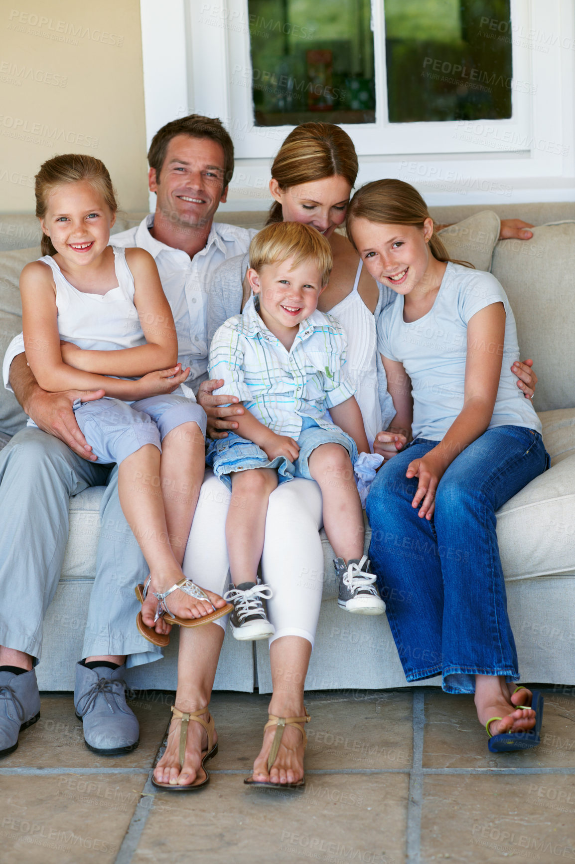 Buy stock photo Family, home and bonding with children on couch, relax and parents with smile on break and together. Happy people, portrait and connection with kids on weekend, mother and father at house in Germany