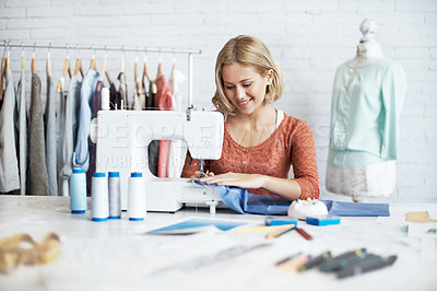 Buy stock photo A beautiful young seamstress sitting and sewing at a sewing machine 