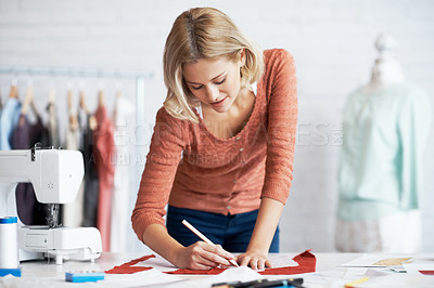 Buy stock photo A beautiful young tailor drawing the outline of a pattern for a garment