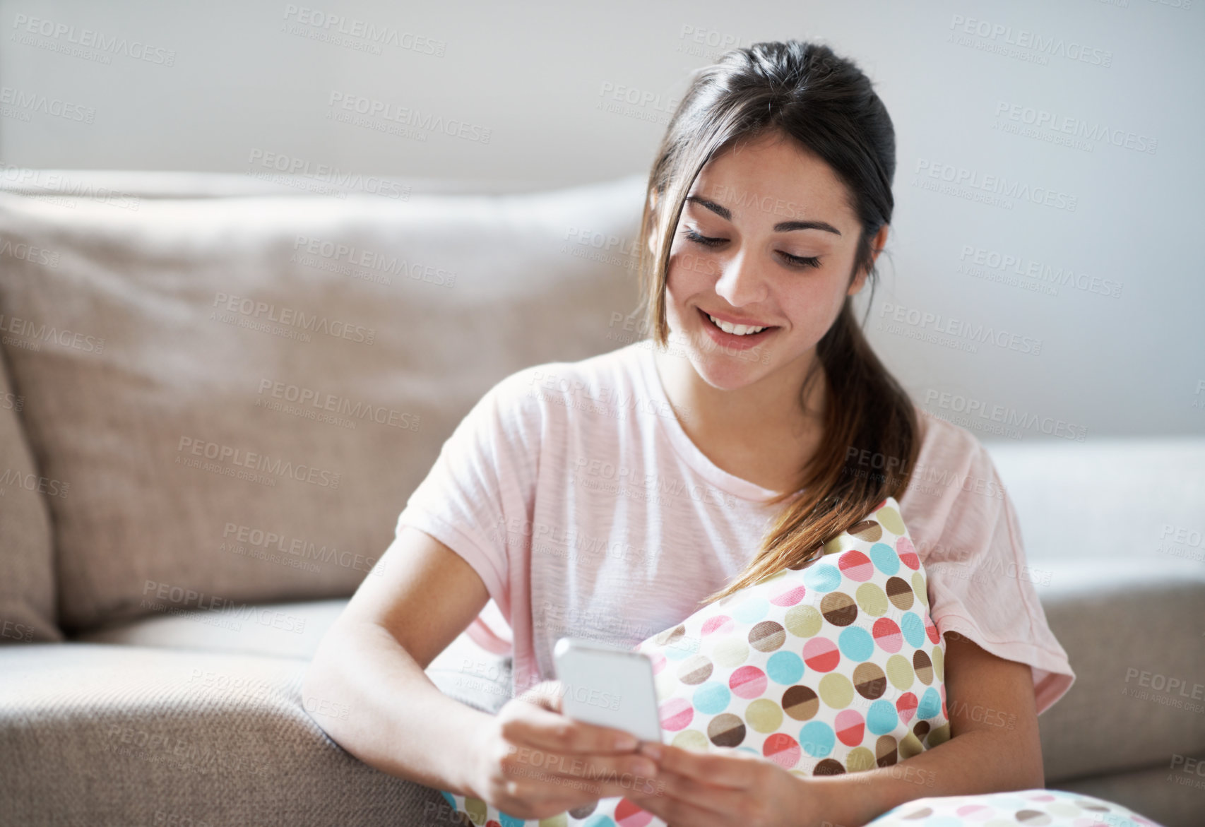 Buy stock photo Teenager, smile and scroll in home with phone, text message notification and internet for social media. Happy, girl relax and browse in living room with tech, online entertainment and mobile chat.