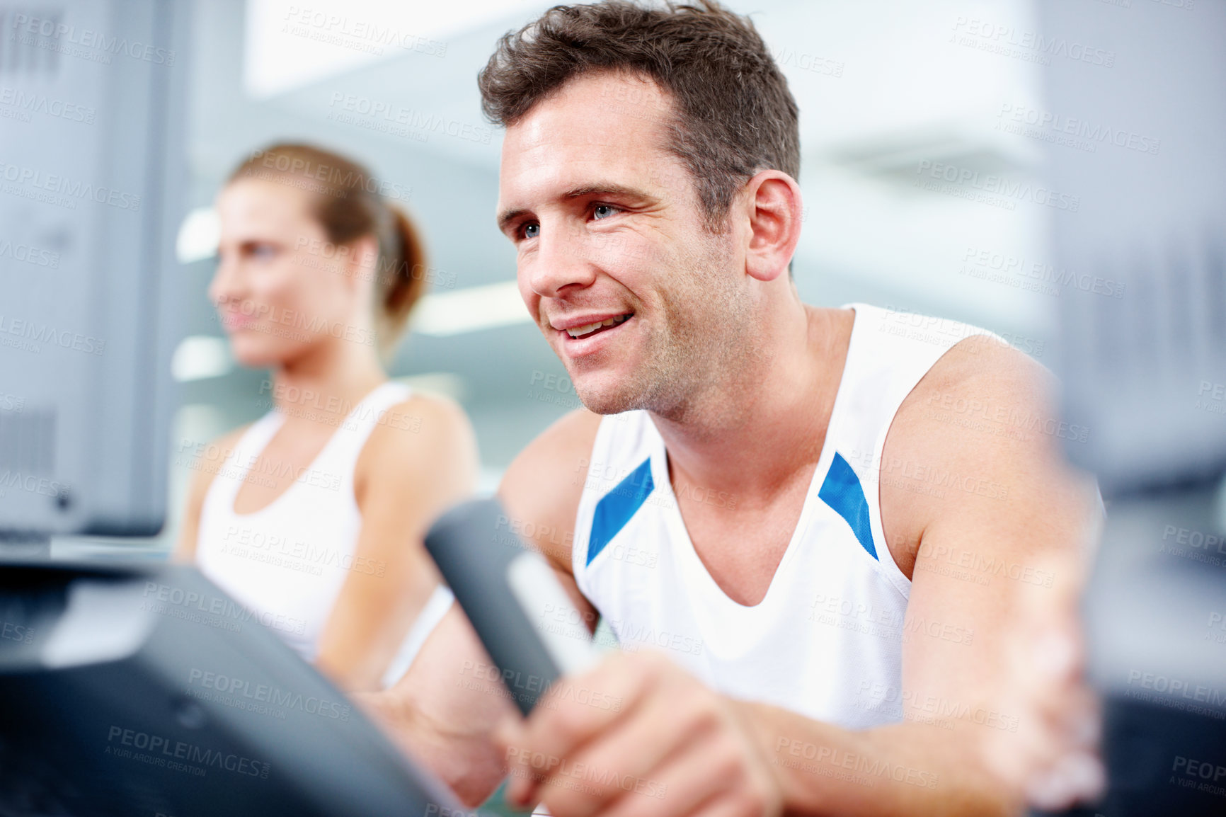 Buy stock photo Gym, sports and man on bike machine for cardio, exercise or cycling training for health. Happy, wellness and person on elliptical equipment in workout class for endurance or active in fitness center.