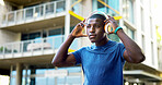 Serious, athlete and man with headphones in city, wellness and streaming music for physical activity. Outdoor, fitness and black person with tech for audio, thinking or bodybuilder with subscription 