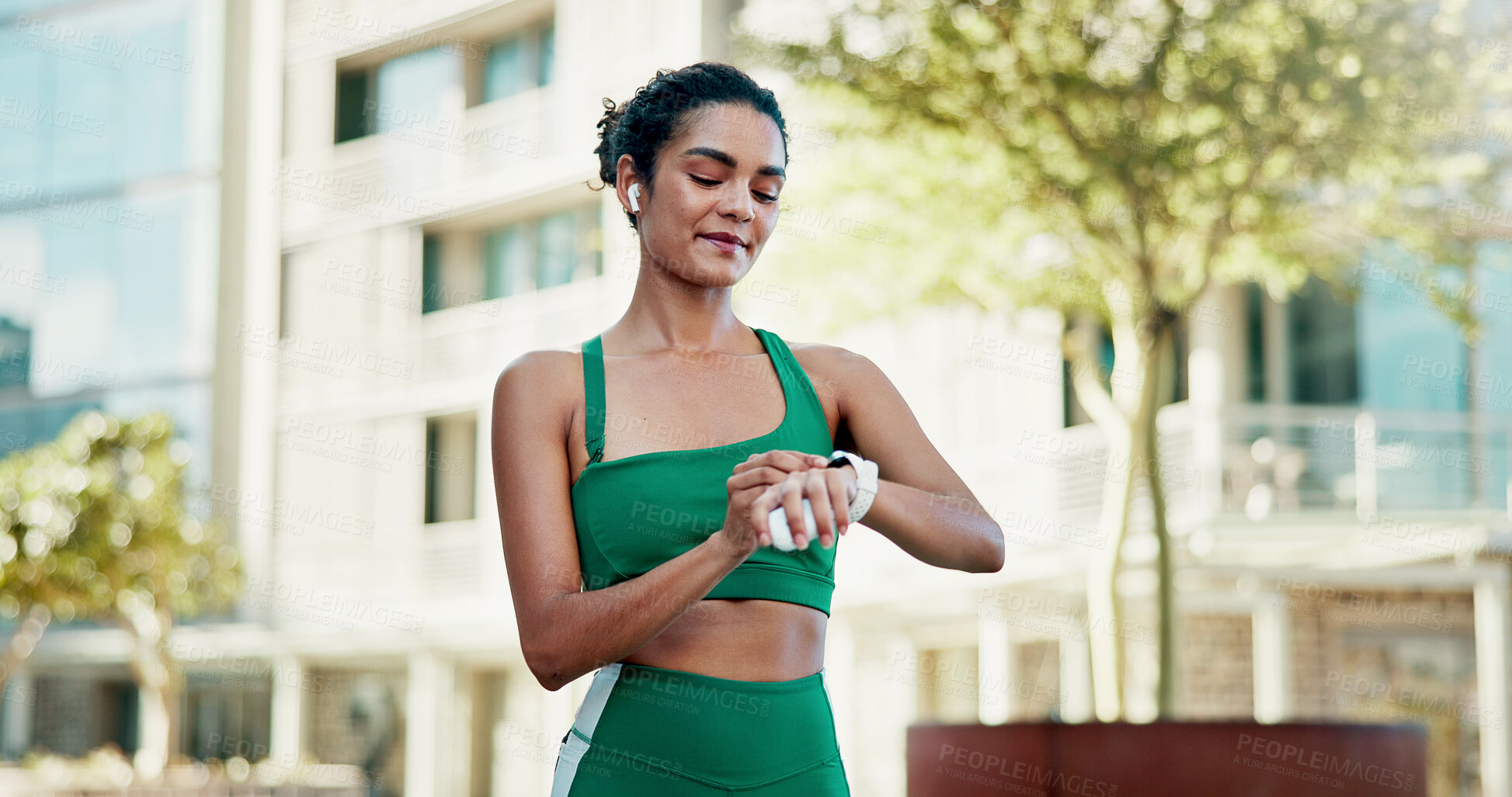 Buy stock photo Fitness, happy and woman with smart watch in city for exercise progress, workout app and health. Sports, runner and person with tech, earphones and time for wellness, training stats and music in town