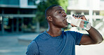Fitness, drinking and black man with water in city for outdoor rest, workout break or hydration. Active, male person or runner with mineral liquid or bottle for nutrition or recovery in an urban town