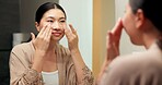 Grooming, mirror and woman in bathroom for skincare, check and dermatology for healthy skin and glow. Reflection, home and Asian person with smile, hygiene and self care with cosmetics for beauty