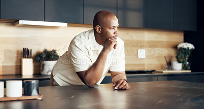 Buy stock photo Thinking, black man on relax on kitchen counter in home, vision and daydreaming for calm morning. Serious, male person and house with reflection, nostalgia memory and perspective for weekend break