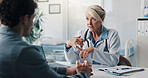 Clipboard, consultation and doctor with man in clinic for discussion on medical diagnosis. Documents, writing and healthcare worker with male patient in conversation for treatment plan in hospital.