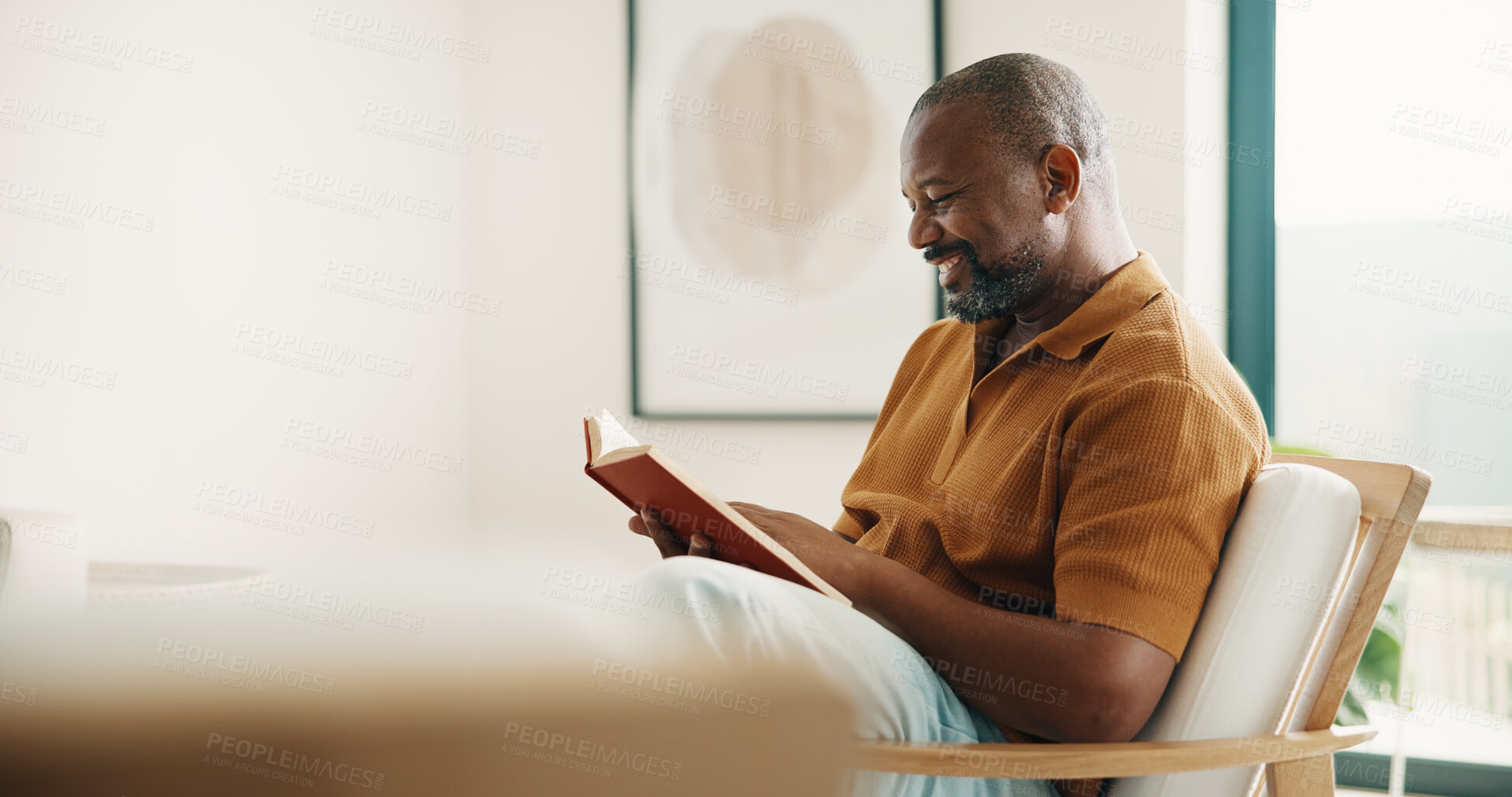 Buy stock photo Reading, relax and smile of black man on chair in home living room for fable or fiction. Space, book and literature story with mature person in apartment for break, fantasy tale or hobby on weekend