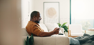 Buy stock photo Smile, phone and relax with black man on sofa in home living room for break or browsing. App, happy and social media with mature person in apartment for planning, research or weekend schedule