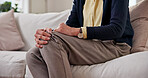 Senior, hands and knee pain on sofa in home for tendinitis, arthritis symptoms and discomfort. Pensioner, old person and tender joint in retirement with stiffness, fibromyalgia risk or muscle tension