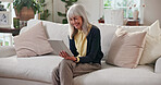 Smile, old woman and relax in home with tablet, social media and streaming movies in lounge. Senior person, rest and reading at house with digital, browsing website and download games in living room