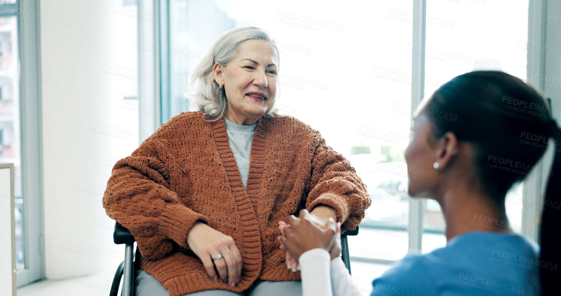 Buy stock photo Clinic, caregiver and holding hands with old woman in wheelchair, support or helping elderly patient. Nurse, consultation and senior person with disability, happy and healthcare services in hospital