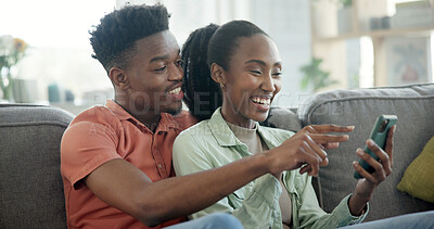 Buy stock photo Couple, online and laughing with phone in lounge, entertainment or streaming video with subscription. Black people, scroll and happy with partner on couch, home and watching funny movie on mobile