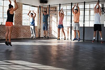 Buy stock photo Shot of a group of people jumping in the air in a fitness class