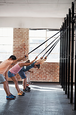 Buy stock photo Shot of a group of people using resistance bands in a crossfit class