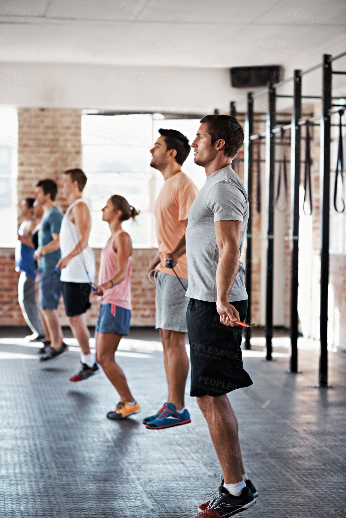 Buy stock photo Coach, exercise and skipping with people in gym together for cardio challenge or physical improvement. Fitness, jump rope and personal trainer with students in health club for training or workout