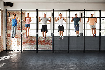 Buy stock photo Shot of a group of people doing pullups in a row in a fitness class