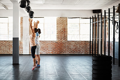 Buy stock photo Shot of a group of people in a fitness class doing a workout with medicine balls at a gym