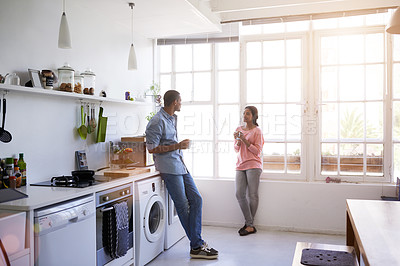 Buy stock photo Full length shot of a young couple talking in the kitchen