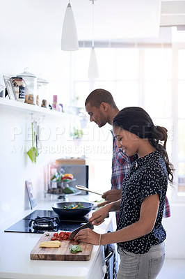 Buy stock photo Cropped shot of a young couple preparing dinner in their kitchen