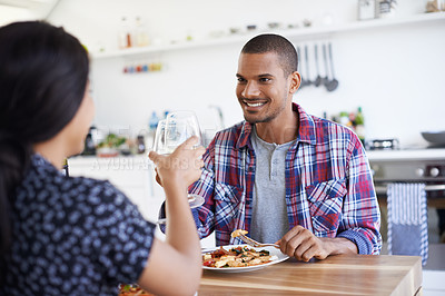 Buy stock photo Cropped shot of a young couple eating dinner in their kitchen