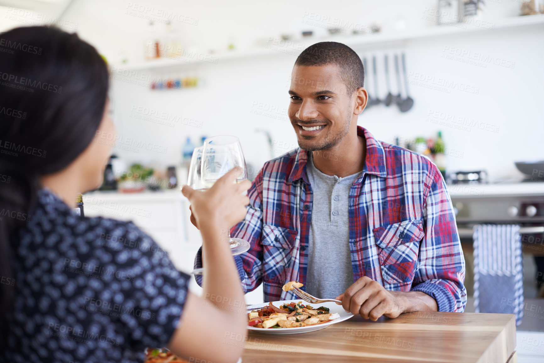 Buy stock photo Cheers, dinner and couple in home for date, bonding or connection in marriage for anniversary. Wine, toast and man with woman for supper or meal together for relationship celebration in apartment.