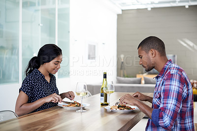 Buy stock photo Cropped shot of a young couple eating dinner in their kitchen