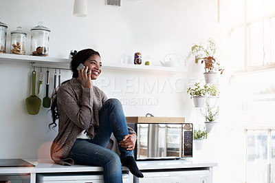 Buy stock photo Cropped shot of a young woman using her cellphone in the kitchen