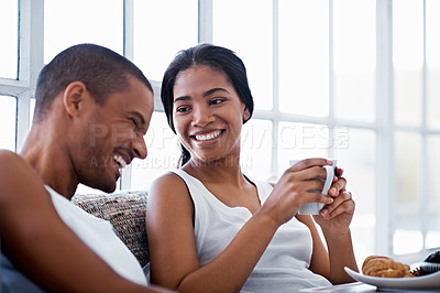 Buy stock photo Shot of a smiling young couple enjoying breakfast in bed together