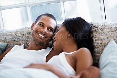 Buy stock photo Shot of a happy young couple talking together while lying in bed