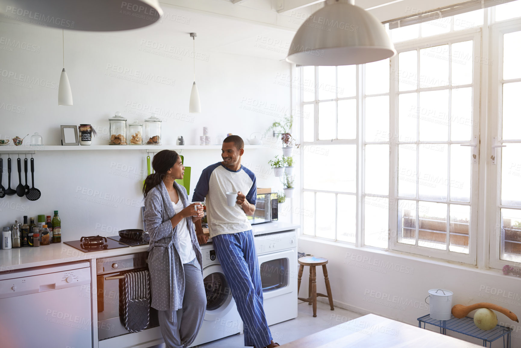 Buy stock photo Coffee, conversation and couple in kitchen at house with bonding, marriage or connection in morning. Happy, talking and man with woman for drinking warm beverage together in apartment on weekend.
