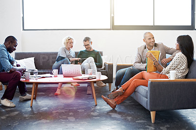 Buy stock photo Shot of a group of coworkers talking together in a modern office