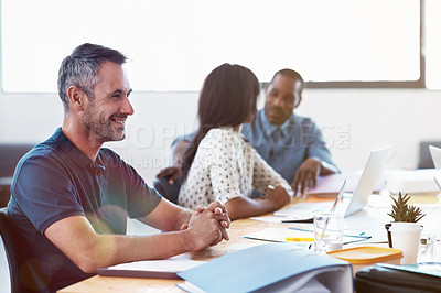Buy stock photo Shot of a smiling office worker with colleagues sitting in the background
