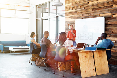 Buy stock photo Shot of a female office worker giving a financial presentation to her colleagues