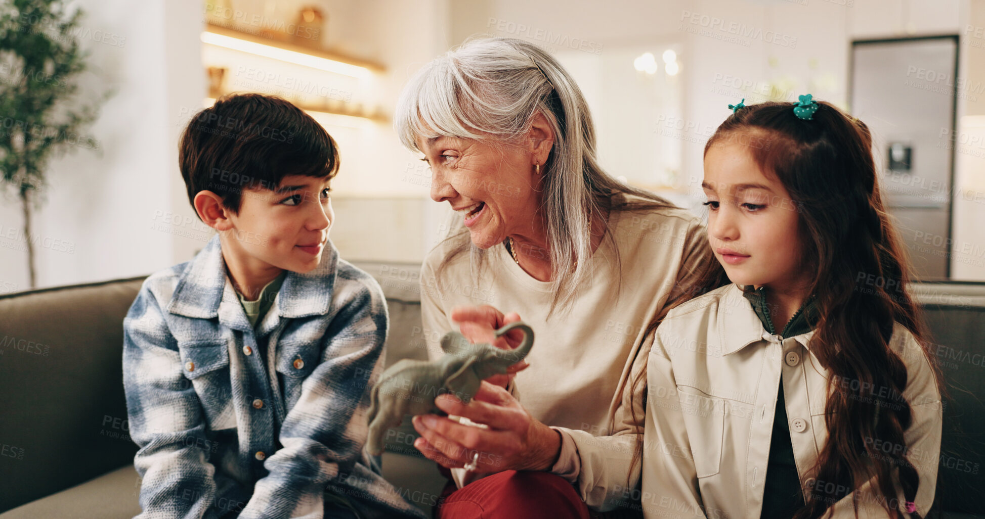 Buy stock photo Happy, toys and grandmother with children on sofa for bonding, love and connection for visit. Family, relationship and kids with grandma for conversation, care and learning with elephant on weekend