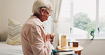 Thinking, anxiety and senior man in bedroom with reflection, remember or memory on past decision. Hearing aid, ideas and elderly person on bed with regret, nostalgia or stress on retirement in home.
