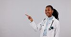 Pointing, studio and portrait of African doctor for medical service, advertising and health mockup. Healthcare, happy and woman with info space for medicare, wellness and news on white background
