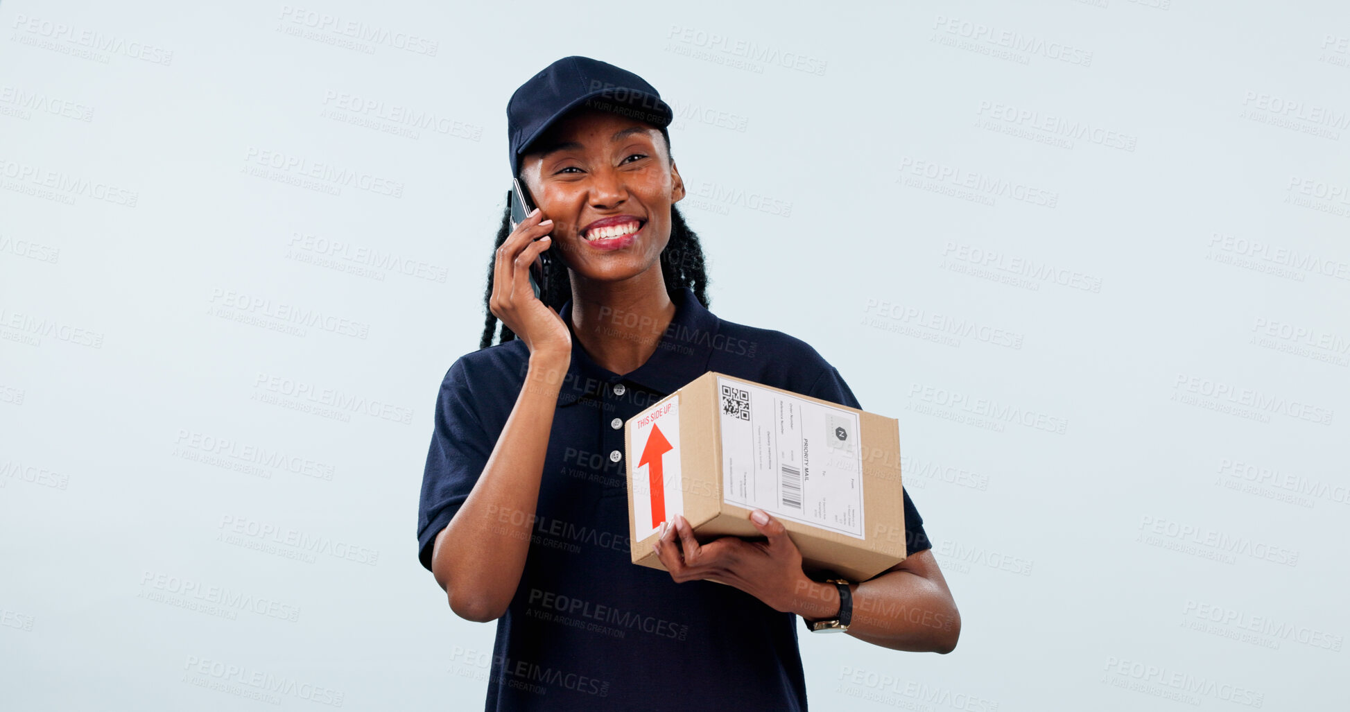 Buy stock photo Box, black woman and portrait of courier with phone call in studio by space for distribution delivery. Happy, cargo and logistics worker on mobile discussion for cardboard parcel on white background.