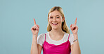 Smile, pointing and fashion with portrait of woman in studio for announcement, retail news and space. Sale promotion, style advertising and happy with female person on blue background for offer