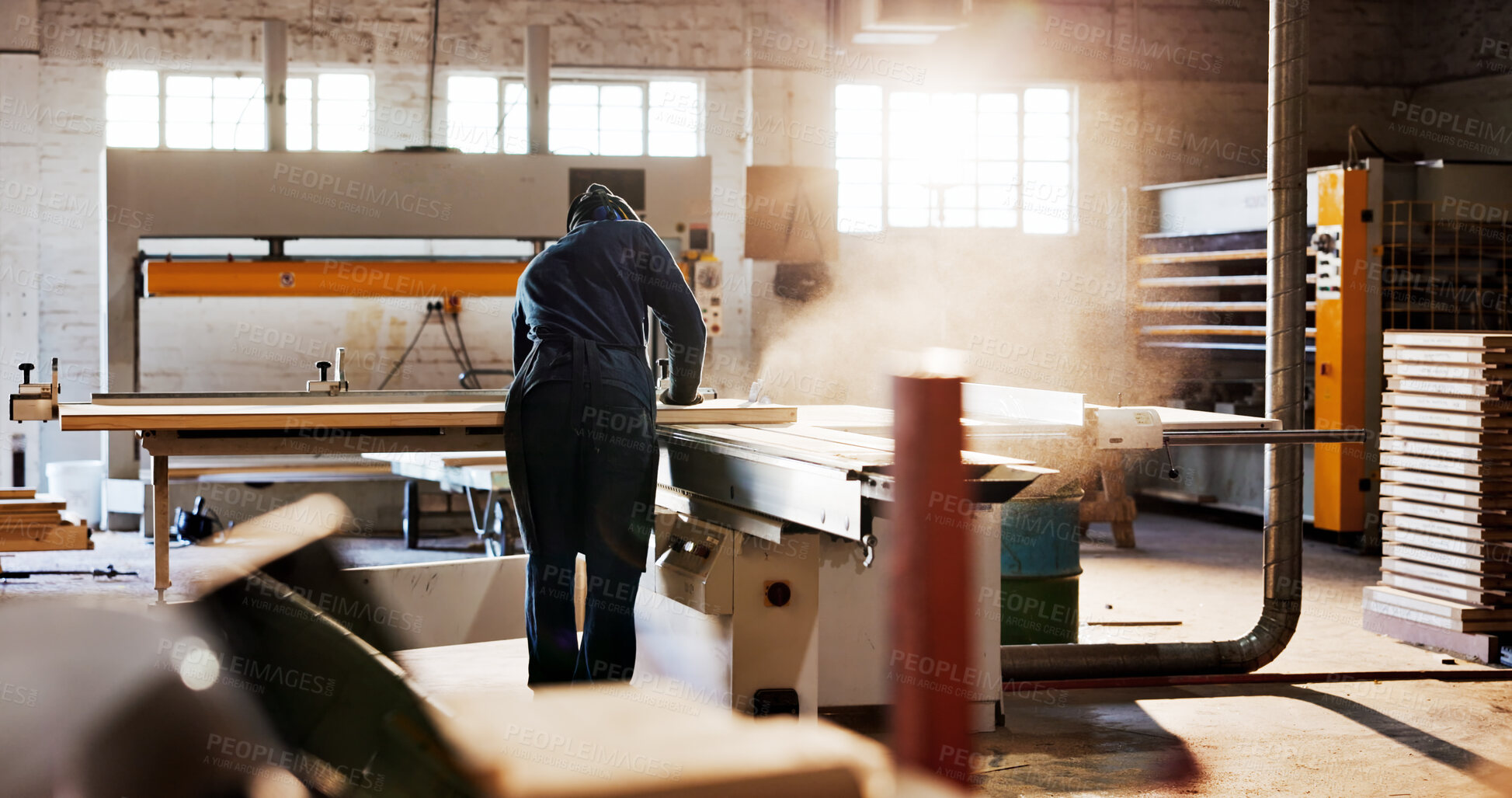 Buy stock photo Saw, machine and back of carpenter in workshop for carpentry, wood project and process with plank. Woodworking, handyman and person with tools for manufacturing, joinery warehouse and equipment