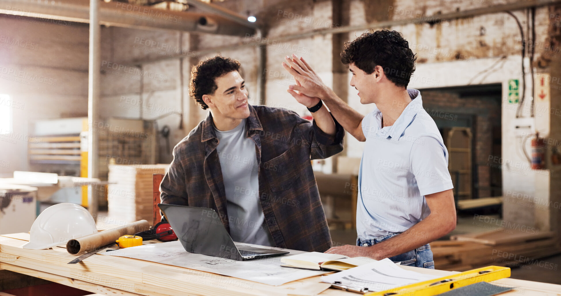 Buy stock photo Carpentry, high five and men with laptop for warehouse, planning and startup collaboration. Furniture, workshop and happy partnership for manufacturing, deal or renovation with lumber project meeting
