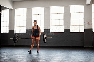 Buy stock photo Shot of a young woman in a gym who has just dropped a barbell she was lifting