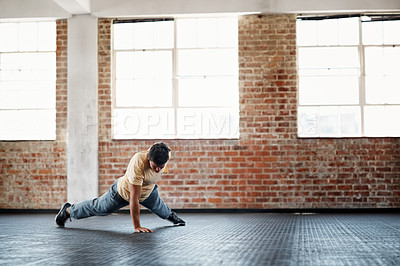 Buy stock photo Shot of a young man in a gym doing one-handed pushups